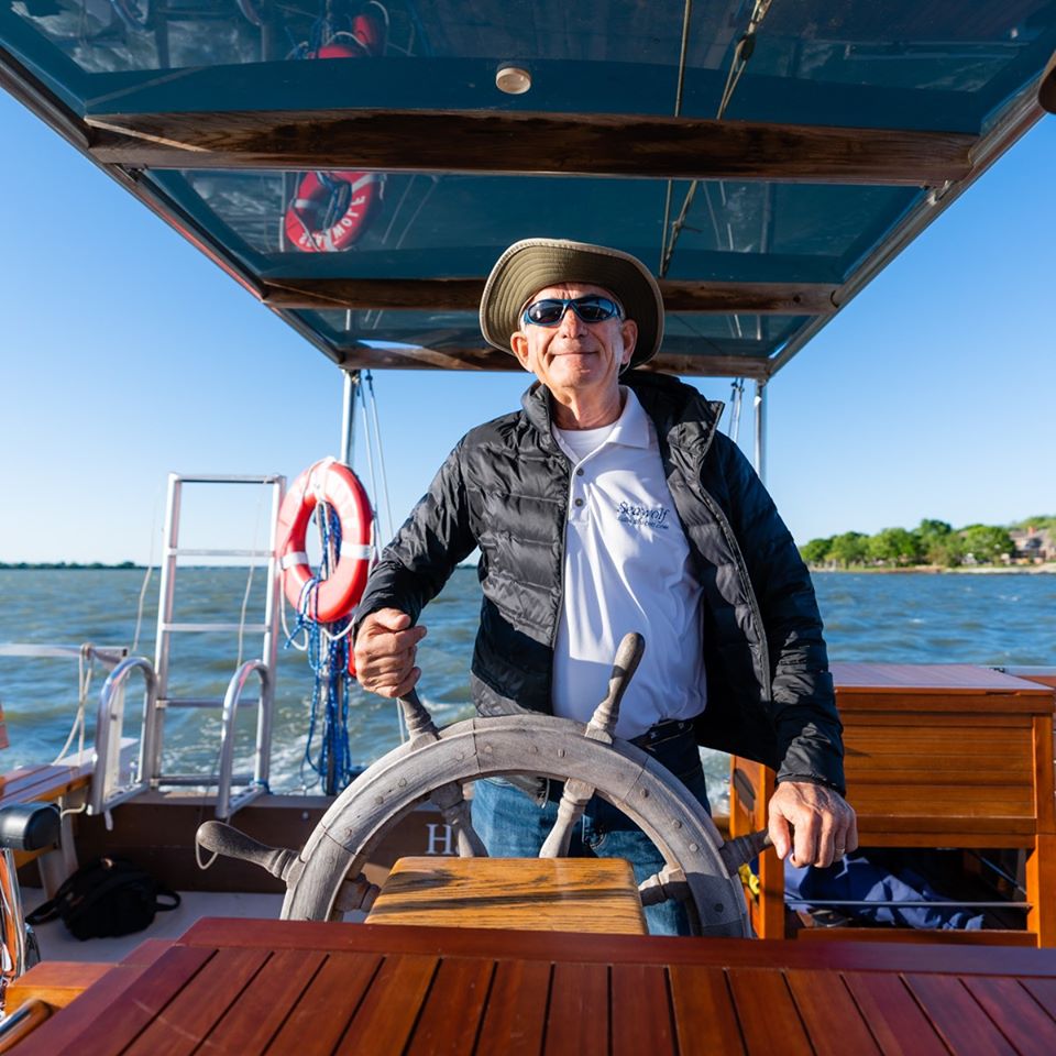 60387795_10156102926741957_3668084271886630912_o Owner Scott standing behind the wheel of his boat